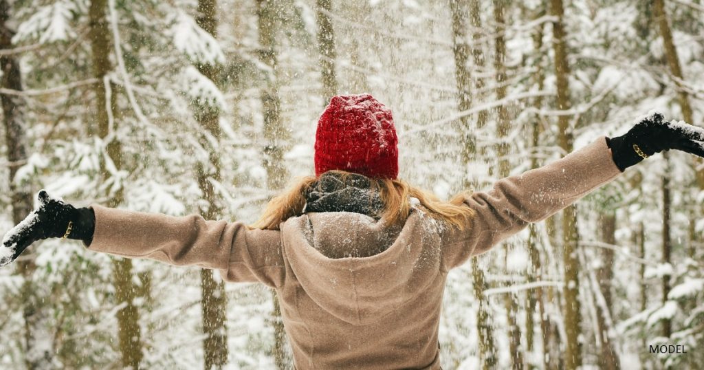 Woman enjoying the snow in a hat and coat